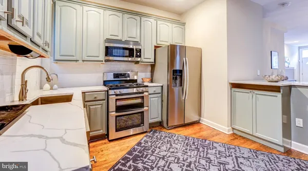 a kitchen with granite countertop a refrigerator and a stove top oven