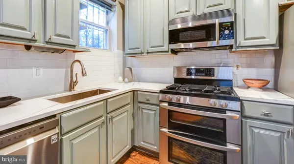 a kitchen with stainless steel appliances a stove microwave and cabinets