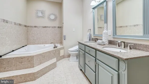 a bathroom with a granite countertop sink mirror and a bathtub