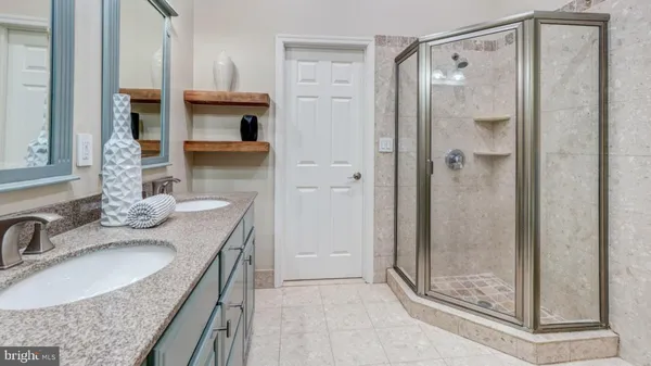 a bathroom with a granite countertop shower a mirror and a sink