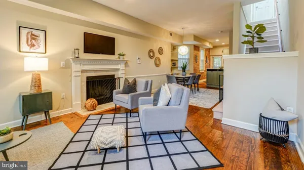 a living room with furniture a flat screen tv and a fireplace