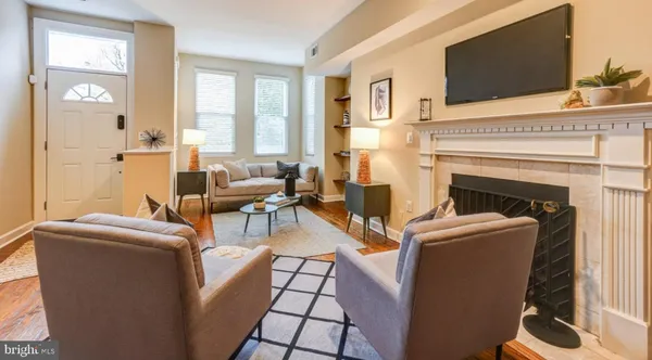 a living room with furniture a flat screen tv and a fireplace