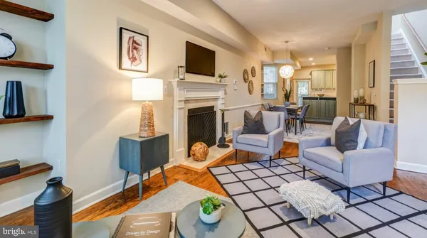 a living room with furniture a flat screen tv and a fireplace