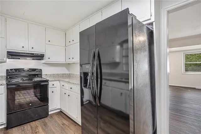 a kitchen with stainless steel appliances granite countertop a refrigerator and a stove top oven