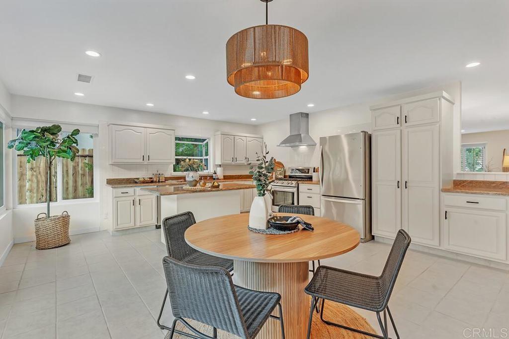 340 Trailview Road Encinitas, CA 92024 - Photo 13 of 35 a kitchen with stainless steel appliances granite countertop a dining table chairs and a refrigerator