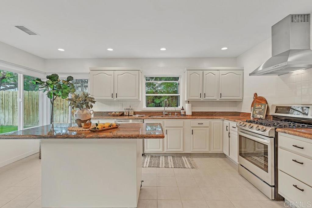 340 Trailview Road Encinitas, CA 92024 - Photo 15 of 35 a kitchen with kitchen island granite countertop white cabinets and white appliances