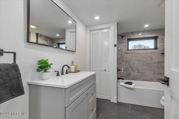 a bathroom with a bathtub sink and mirror
