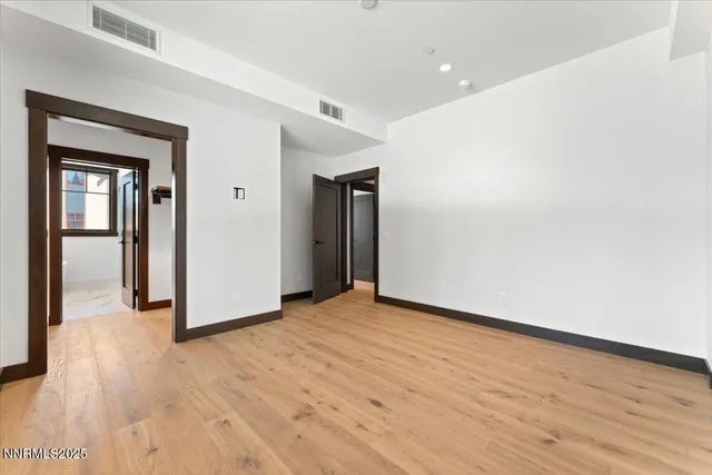 a view of a hallway with wooden floor and closet