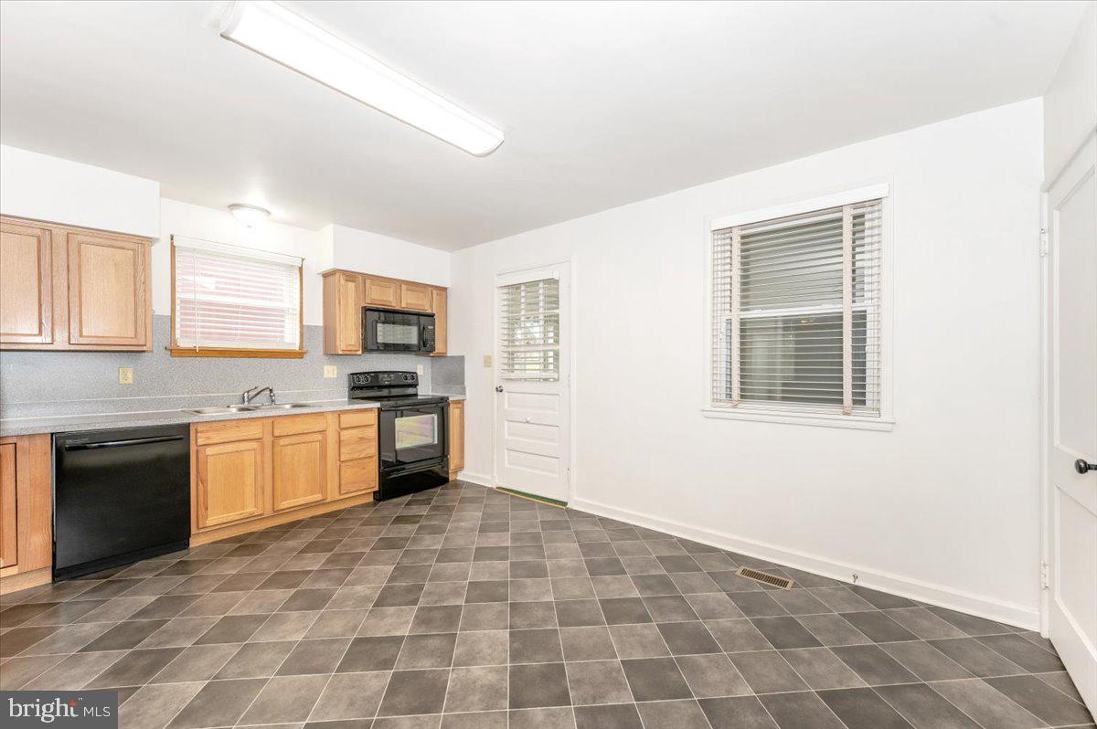 12514 Creagerstown Road Thurmont, MD 21788 - Photo 8 of 57 a large kitchen with a stove top oven microwave and cabinets