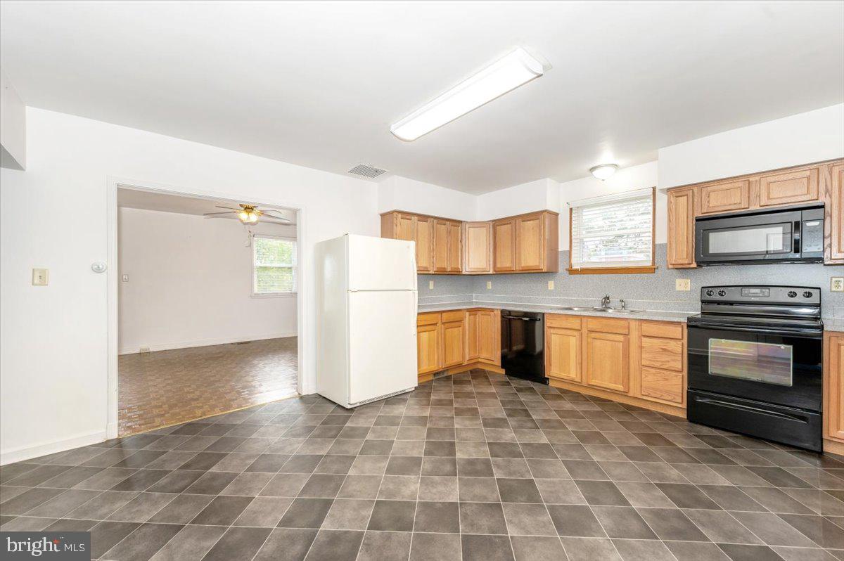 12514 Creagerstown Road Thurmont, MD 21788 - Photo 9 of 57 a kitchen with a refrigerator a stove top oven and cabinets
