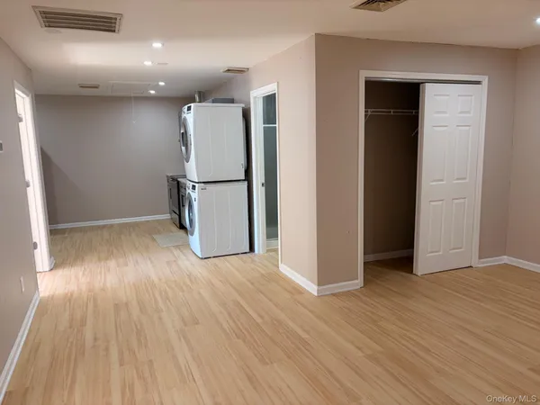 an empty room with wooden floor and entrance