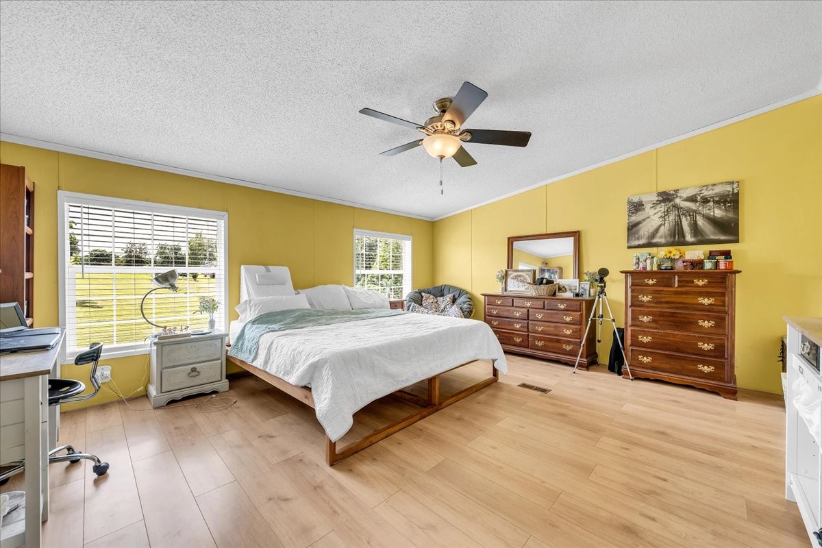 2657 Oak Grove Road Red Boiling Springs, TN 37150 - Photo 13 of 45 a spacious bedroom with a bed a dresser and large window