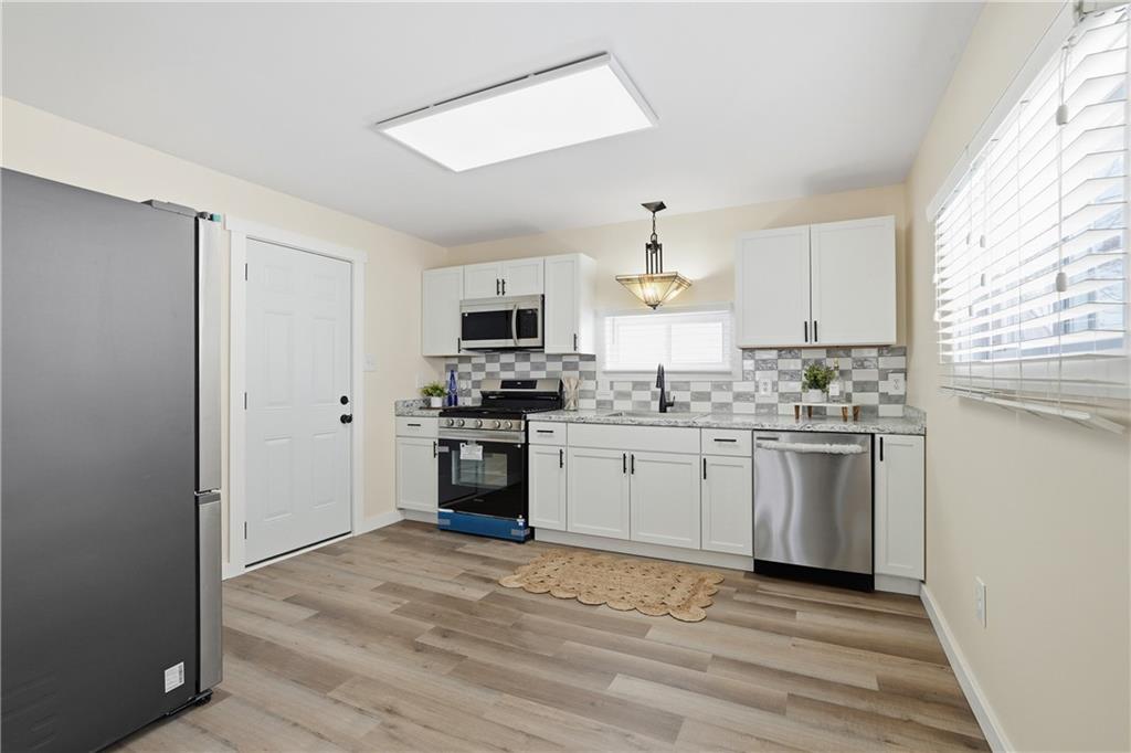 805 Colonial Avenue Monaca, PA 15061 - Photo 13 of 30 a kitchen with granite countertop white cabinets and stainless steel appliances