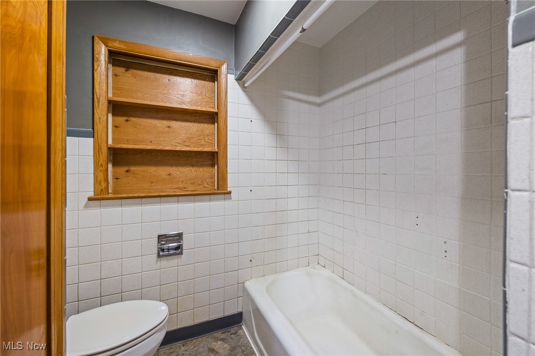 718 Fairwood Road Akron, OH 44319 - Photo 9 of 15 Bathroom with shower / bath combination, toilet, tile patterned floors, and tile walls