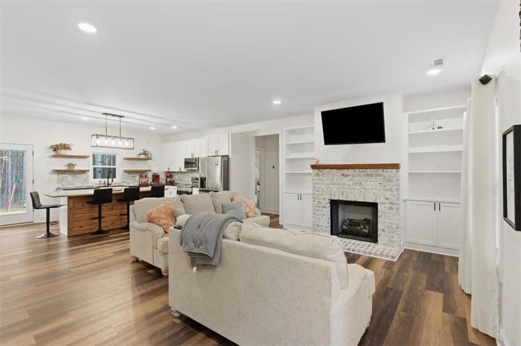 1475 Ben Davis Road Buchanan, GA 30113 - Photo 7 of 61 a living room with furniture a fireplace and a flat screen tv