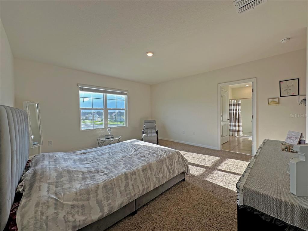 6988 Botanic Boulevard Harmony, FL 34773 - Photo 20 of 61 a bedroom with a bed and a window