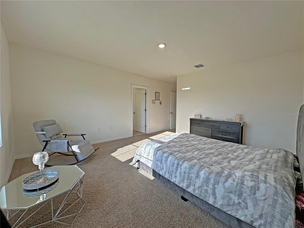 6988 Botanic Boulevard Harmony, FL 34773 - Photo 21 of 61 a bedroom with a bed and couch