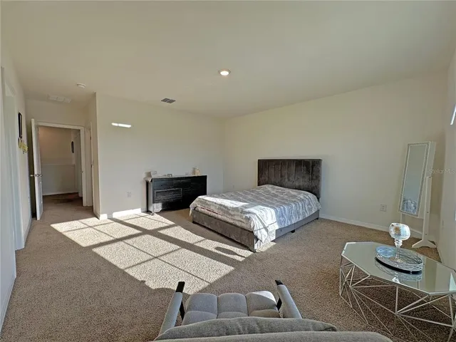 a bedroom with a bed and a dresser next to a window