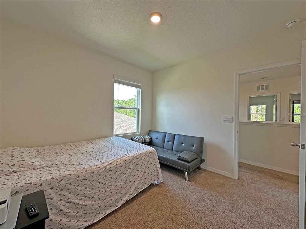 6988 Botanic Boulevard Harmony, FL 34773 - Photo 24 of 61 a bedroom with a bed and a window