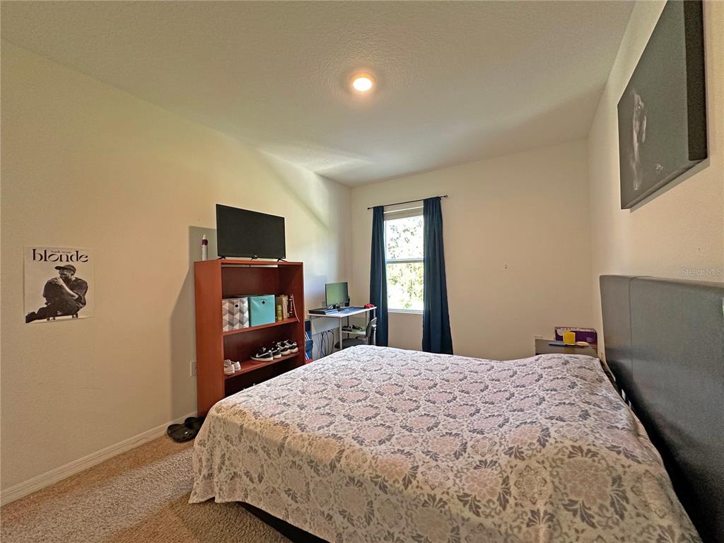 6988 Botanic Boulevard Harmony, FL 34773 - Photo 25 of 61 a bedroom with a bed and a flat screen tv