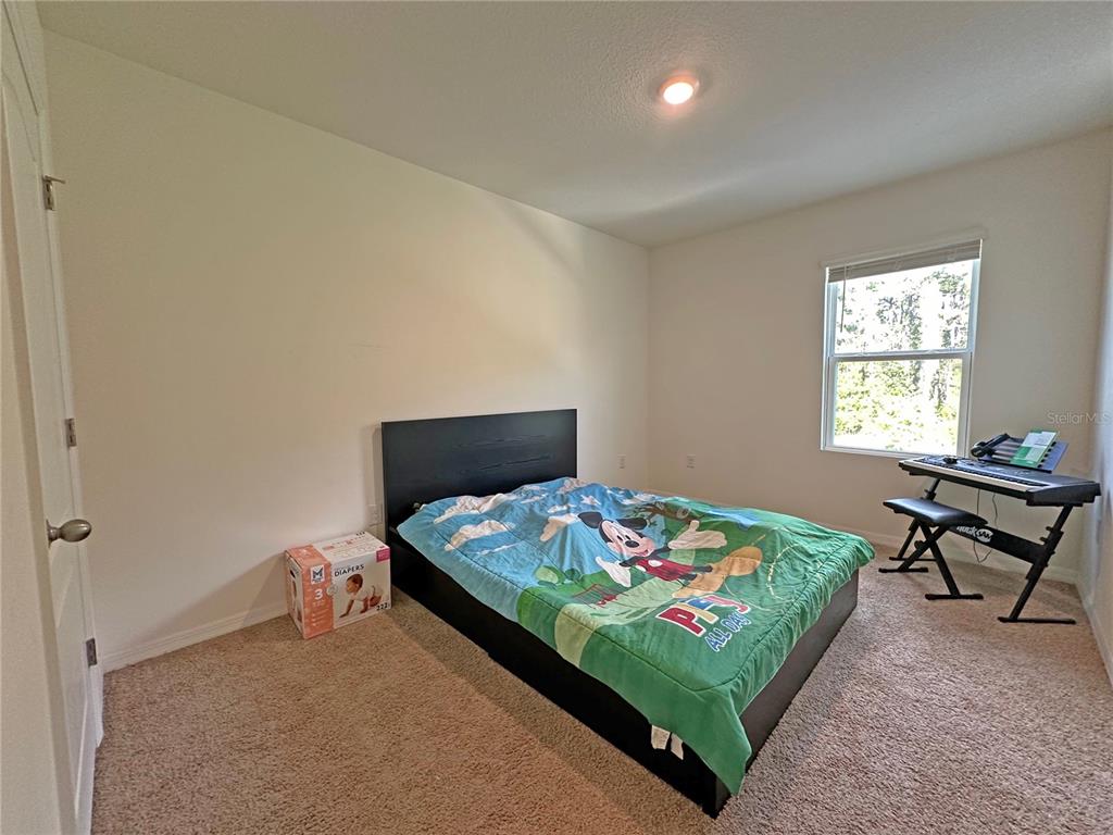 6988 Botanic Boulevard Harmony, FL 34773 - Photo 27 of 61 a bedroom with a bed and a window