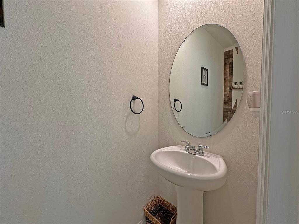 6988 Botanic Boulevard Harmony, FL 34773 - Photo 35 of 61 a bathroom with a sink and mirror