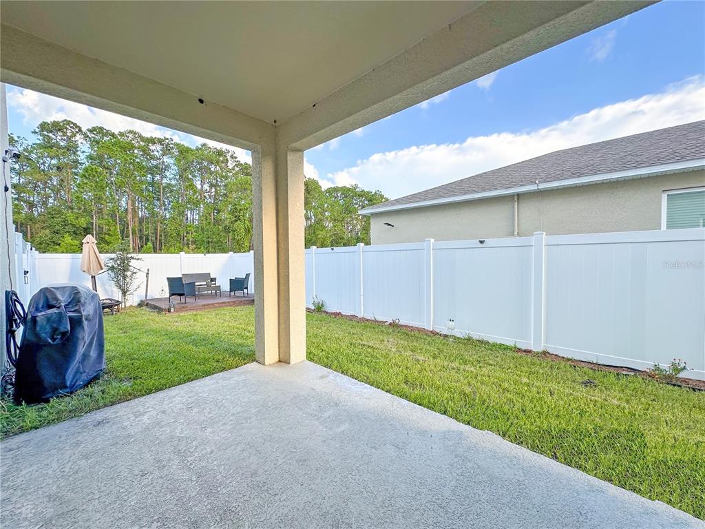 6988 Botanic Boulevard Harmony, FL 34773 - Photo 37 of 61 a view of a backyard with table and chairs and garden