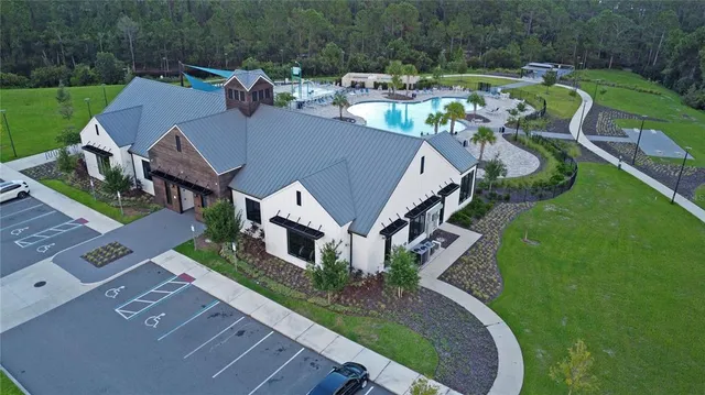 a view of swimming pool with lawn chairs and plants