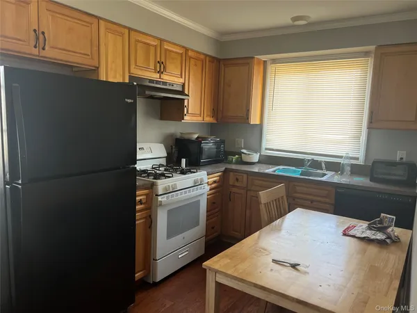 a kitchen with granite countertop a refrigerator stove top oven and sink