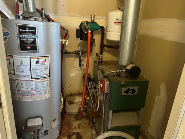 a room with water heater refrigerator washer and dryer