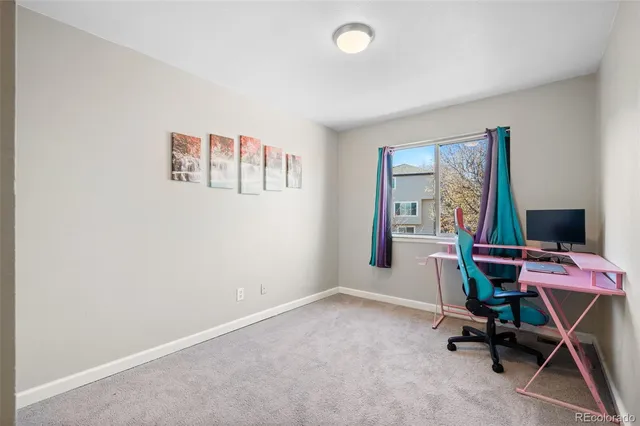 a view of a workspace with furniture and a window