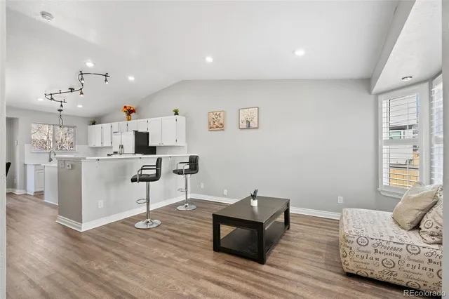 a living room with furniture and view of kitchen