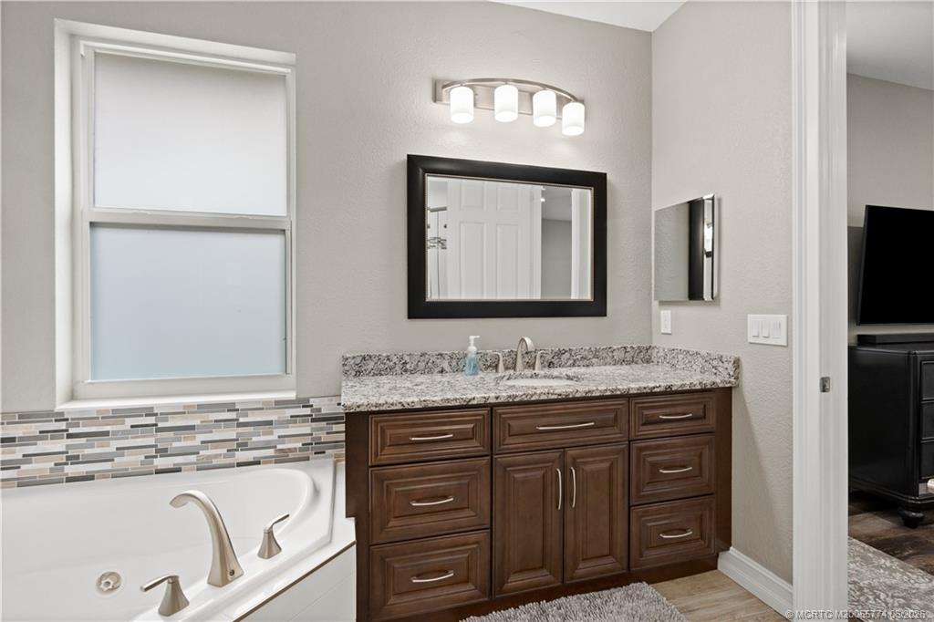 1268 Southeast Kirk Street Stuart, FL 34997 - Photo 37 of 63 a bathroom with a granite countertop double vanity sink and mirror