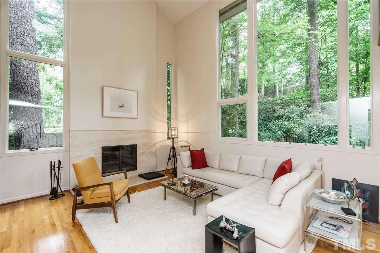 3606 Swann Street Raleigh, NC 27612 - Photo 3 of 25 Flooded with natural light, the living area is also made cozy by the wood burning fireplace surrounded by Italian travertine.