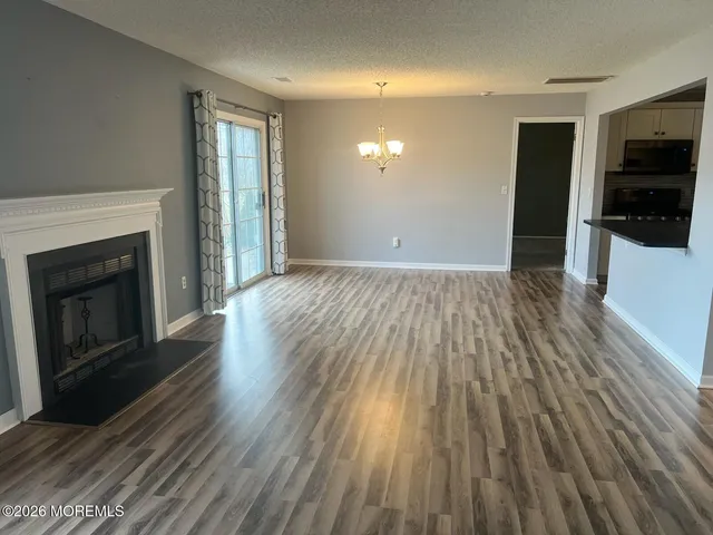 wooden floor fireplace and windows in an empty room