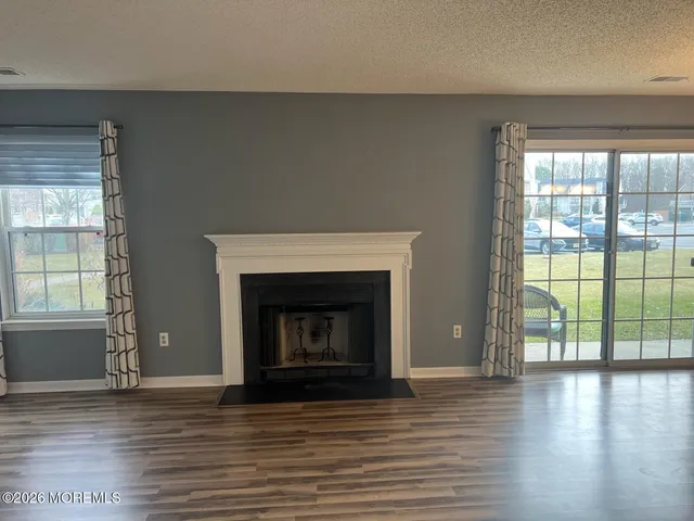 wooden floor fireplace and windows in an empty room
