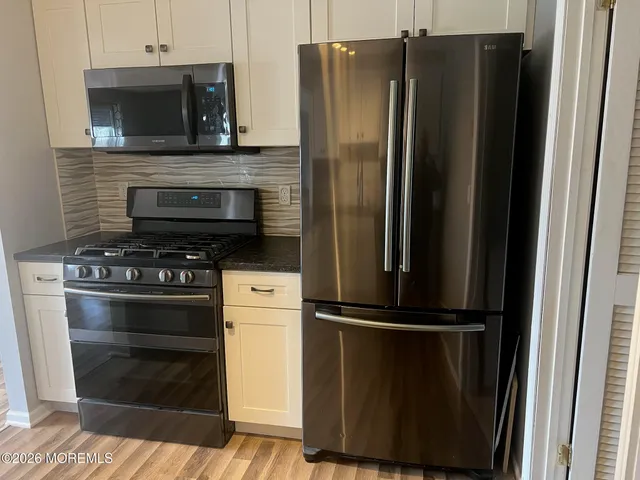 a kitchen with a refrigerator stove and cabinets
