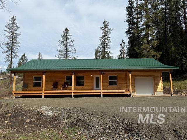 124 Windmill Lane Kooskia, ID 83539 - Photo 1 of 50 Log home with a metal roof, a porch, a garage, and driveway