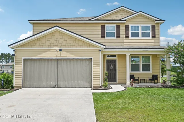 a front view of a house with a yard and garage
