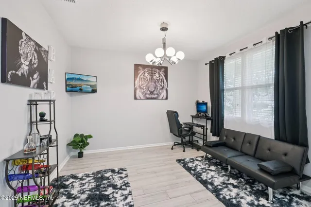 a living room with furniture chandelier and a potted plant