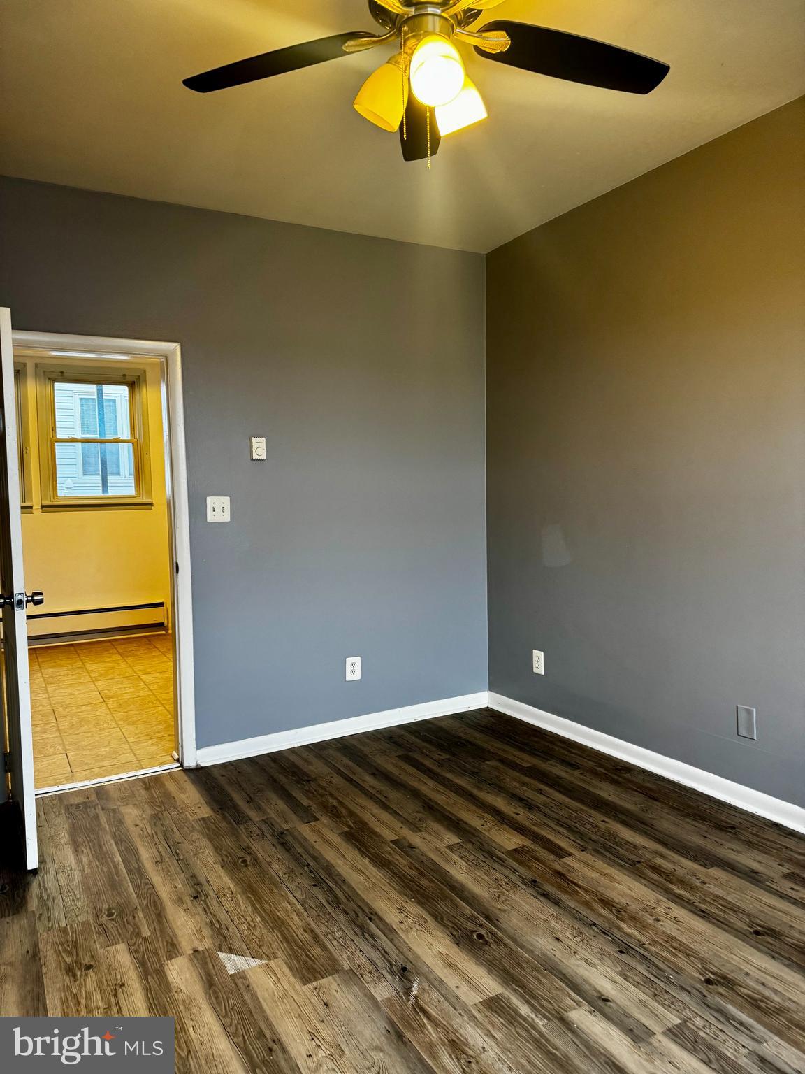 6604 O Donnell Street, Unit A Baltimore, MD 21224 - Photo 12 of 13 a view of an empty room with a window and wooden floor