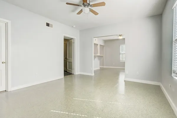 an empty room with a ceiling fan and a window
