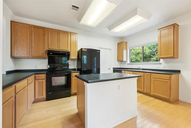 a kitchen with granite countertop stainless steel appliances a stove sink and microwave