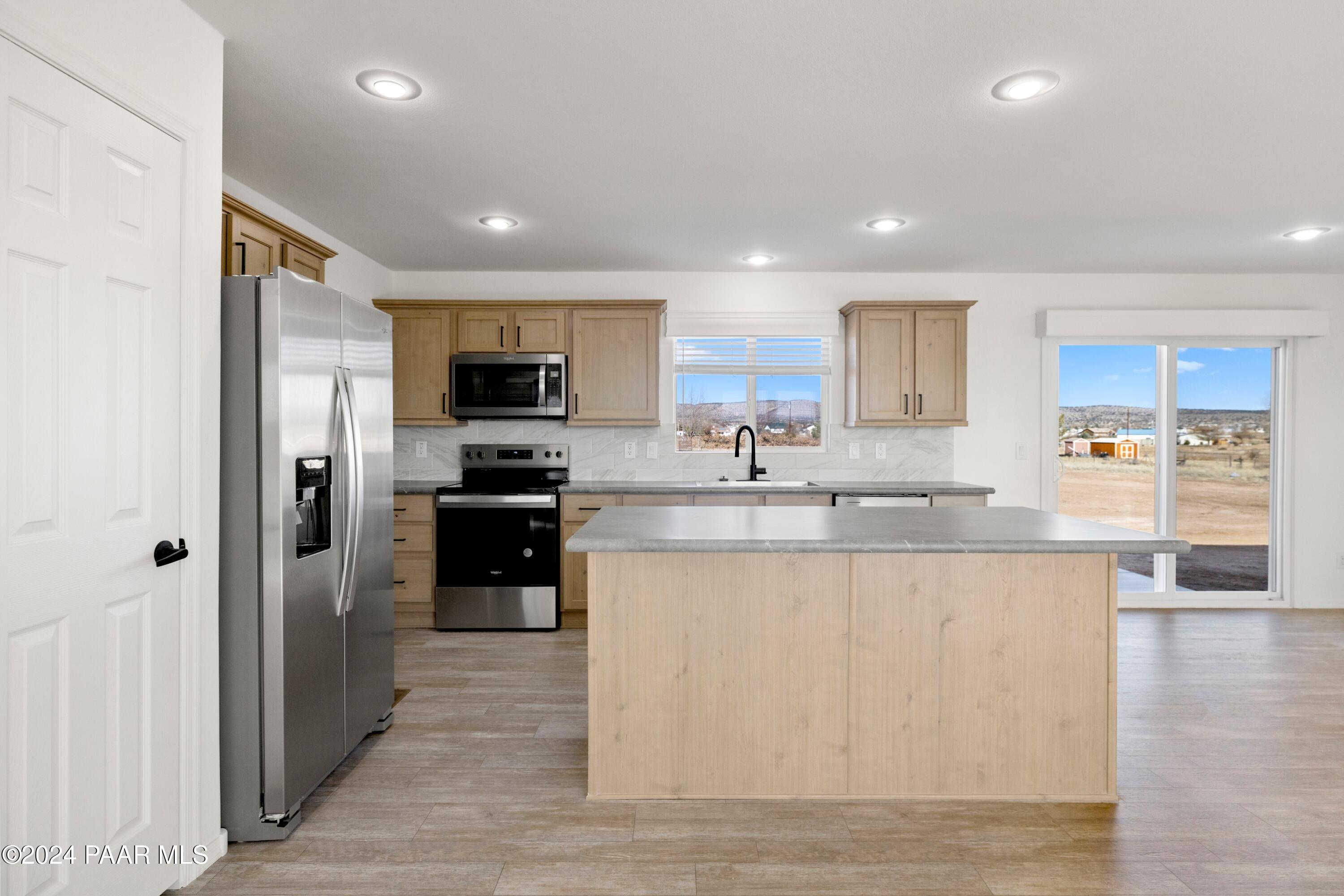1460 Saddle Road Paulden, AZ 86334 - Photo 5 of 27 a large kitchen with stainless steel appliances granite countertop a stove a sink and a refrigerator