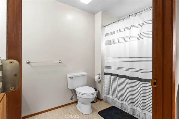 a bathroom with a toilet and a shower curtain