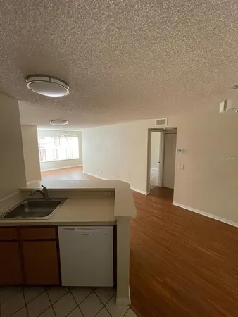 a kitchen with a sink and wooden floor