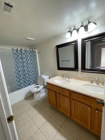 a bathroom with a double vanity sink mirror and toilet