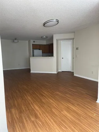 a view of a room with wooden floor and white walls