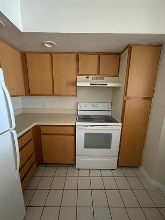 a kitchen with a stove top oven cabinets and a refrigerator