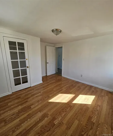 a view of empty room with wooden floor and windows